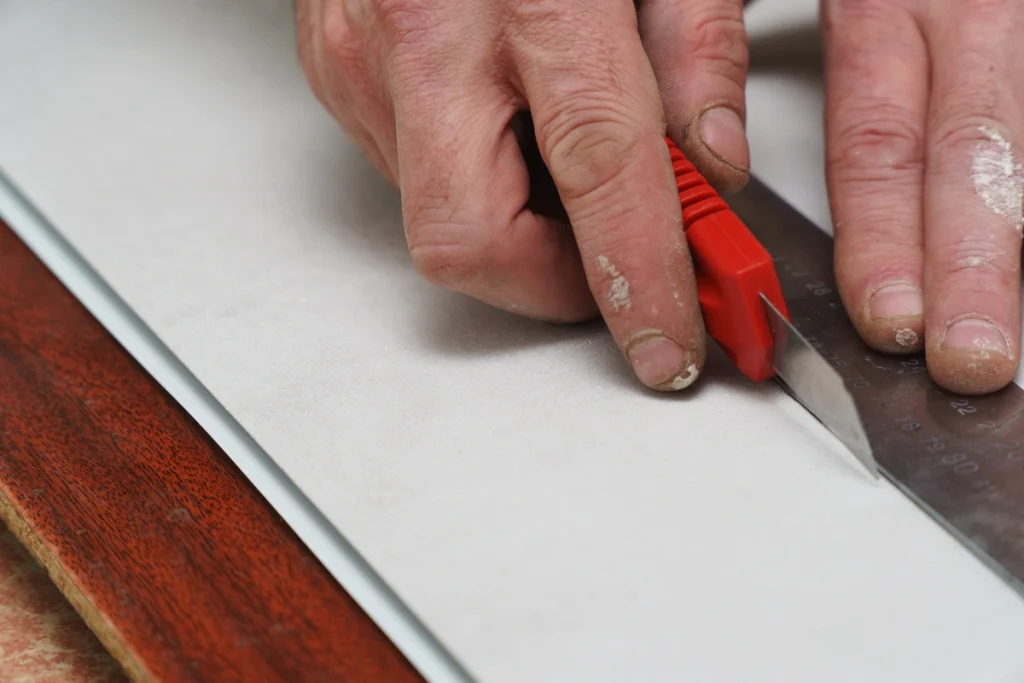 using a utility knife to cut vinyl siding