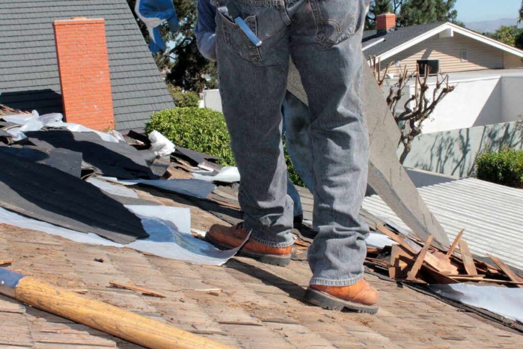 parts of a roof asphalt shingles close up worker replacing old shingles
