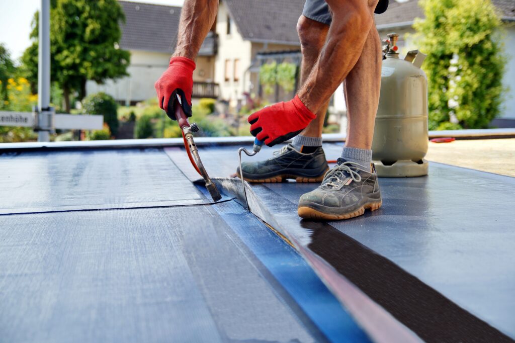 modified bitumen roof worker repairing flat roof