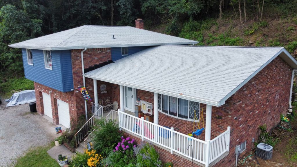 A two-story house with red brick and blue siding, white trim, and a gray shingle roof