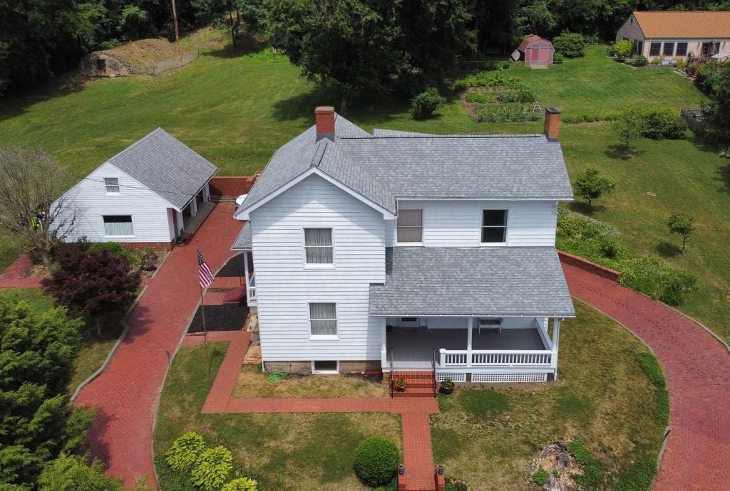Aerial view of a white two-story house with a gray roof