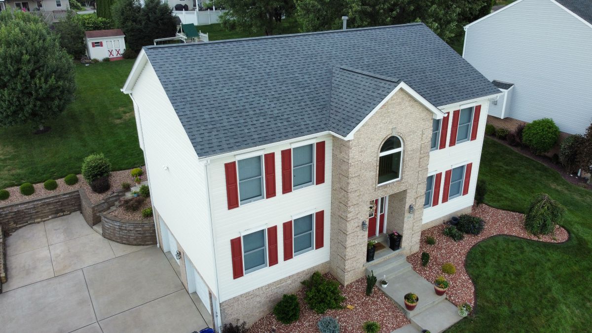 A two-story house with white siding, red shutters