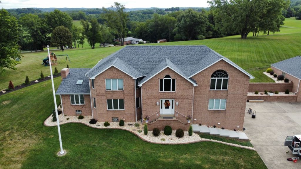 A large two-story brick house with multiple gables and expert roofing