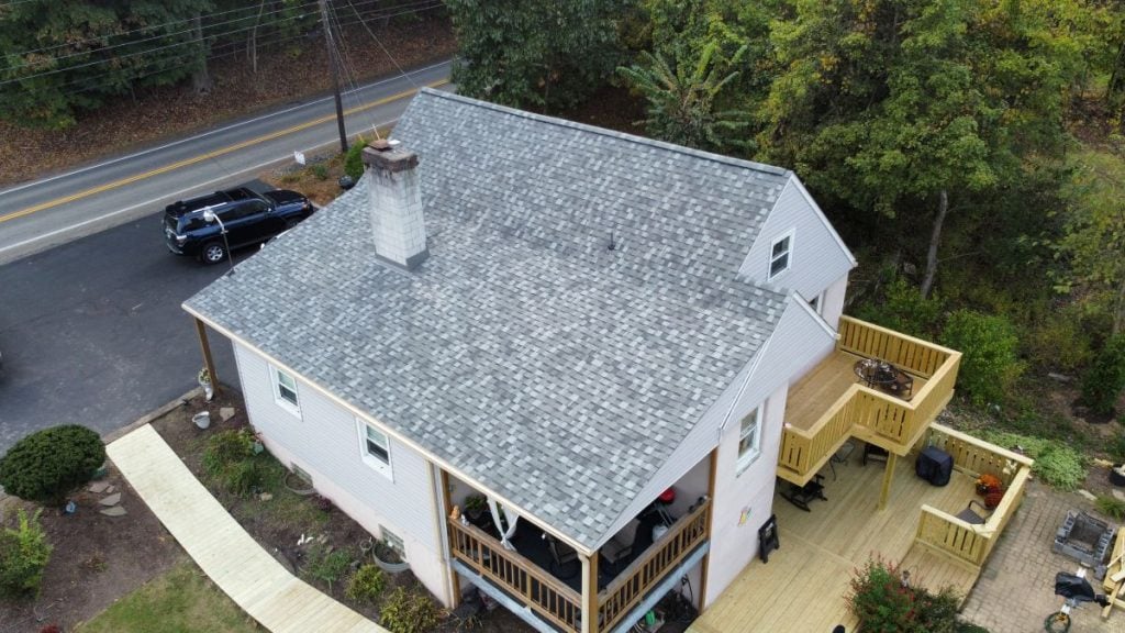 Aerial view of a light-colored house with a gray shingle roof