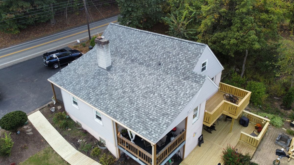 Aerial view of a light-colored house with a gray shingle roof