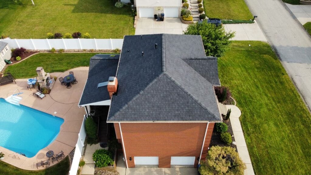 A house with newly installed shingles, the backyard has a pool
