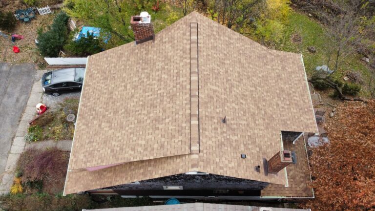 Aerial view of a house with a tan shingle roof
