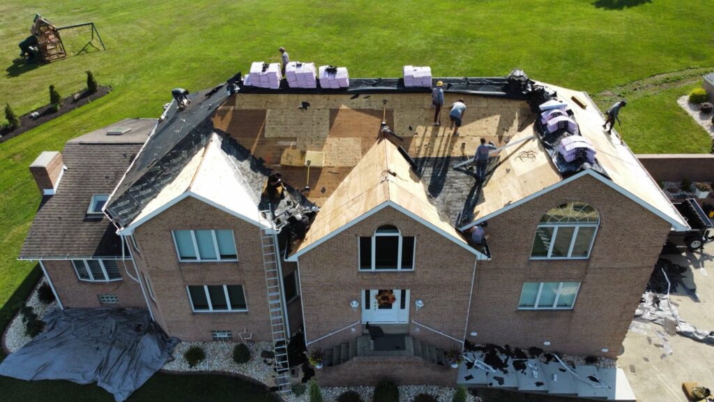 roof replacement cost Murrysville McCormick workers replacing big house roof
