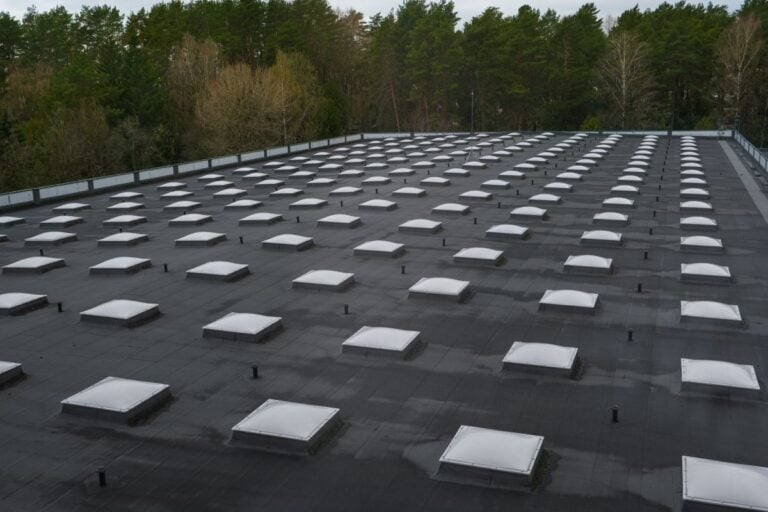 rubber roof repair black commercial building with white panels