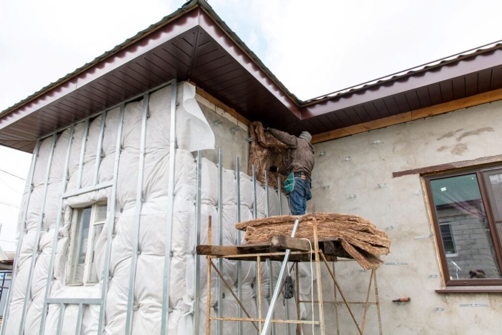 siding insulation worker installing wool