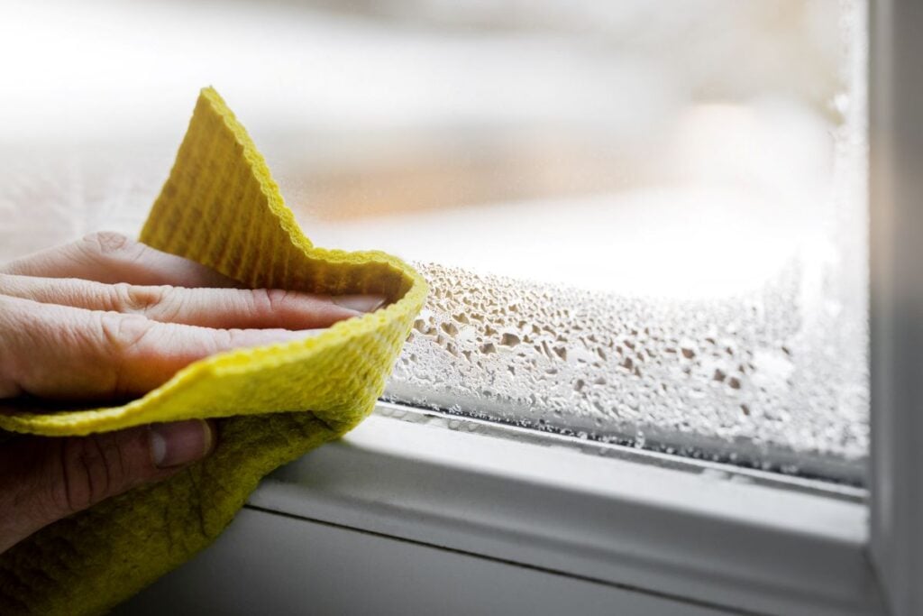 window condensation hand cleaning white frame
