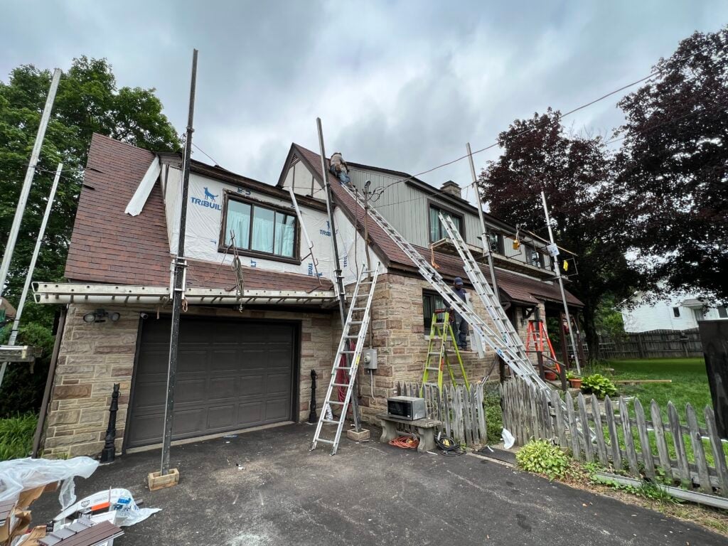 siding companies in Pittsburgh ladders siding replacement brown shingles small house cloudy sky