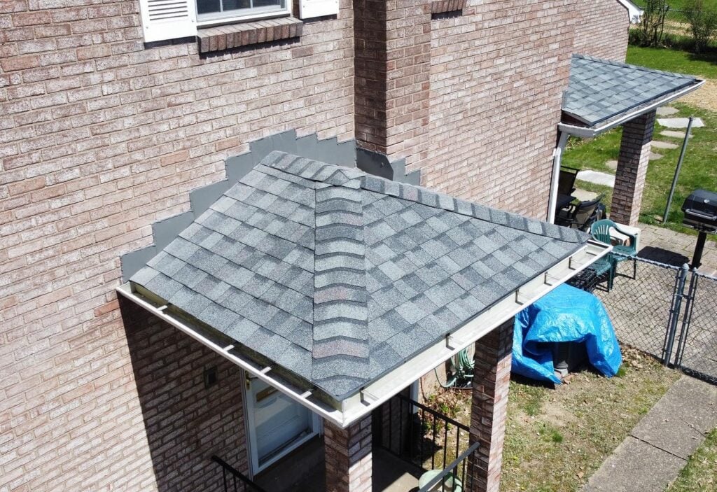 roof replacement cost Greensburg dark grey shingles roof orange brick wall