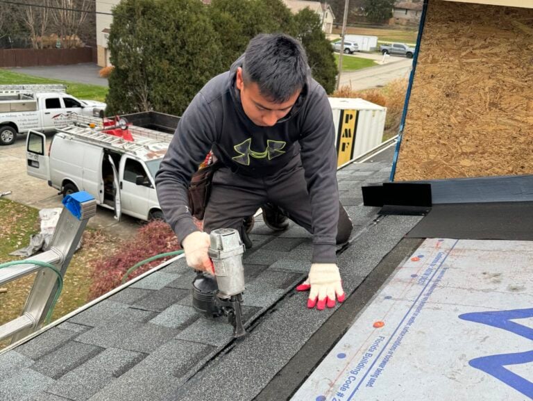 roof replacement timeline worker using nailgun to paste shingles