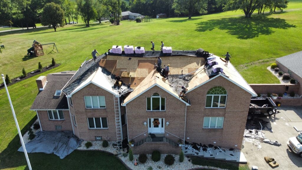 roof replacement cost Irwin aerial view of roof  replacement project workers on top of roof