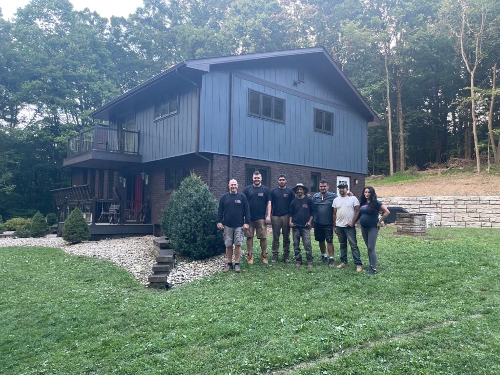 siding companies in Murrysville paper on siding workers standing in front of house
