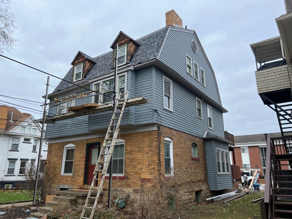 siding companies in Greensburg ladders against house