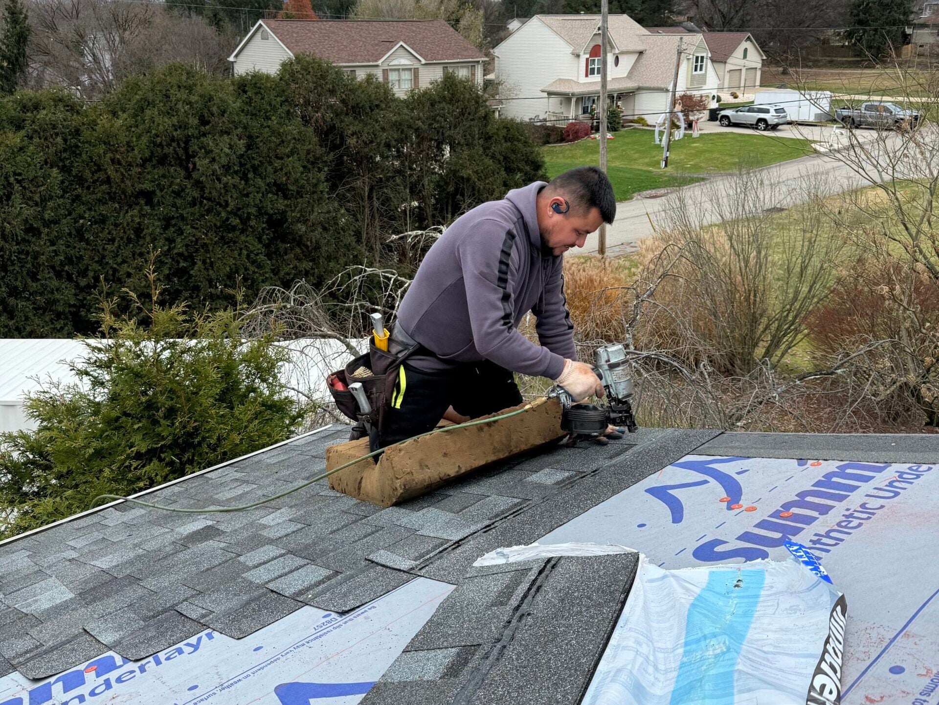 roof replacement cost Irwin worker replacing shingles