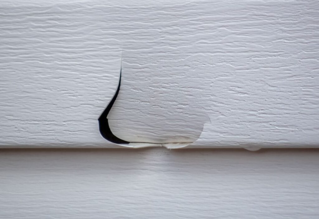 hail damage siding close up small hole