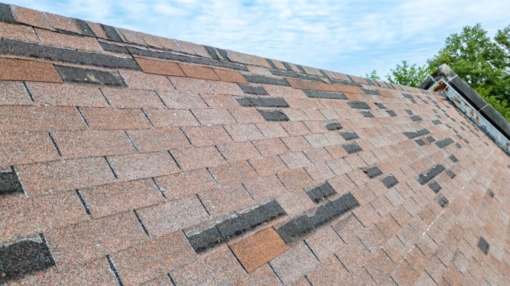Roof with missing shingles from storm damage and old age