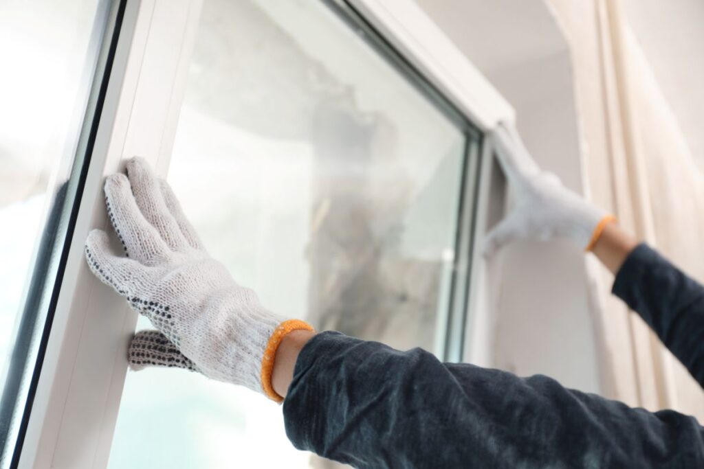 handyman with white gloves installing windows