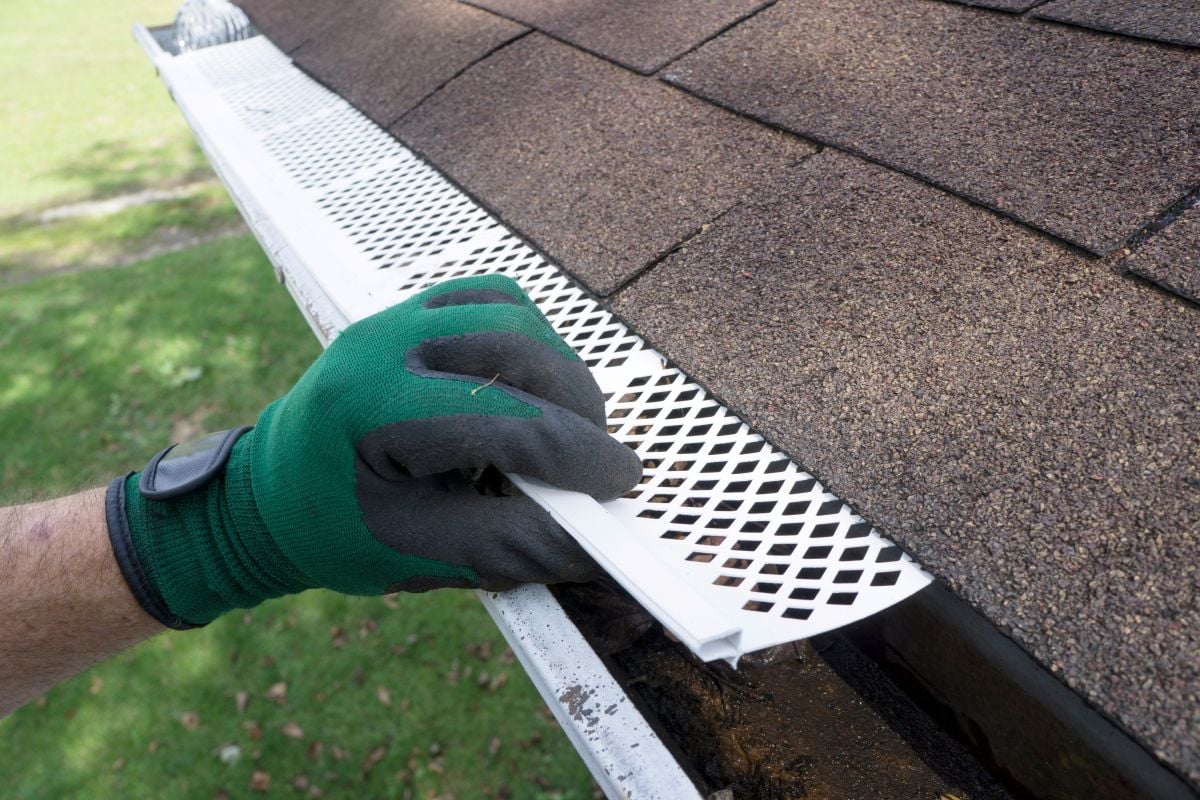 Contractor Adjusting Plastic Gutter Guards