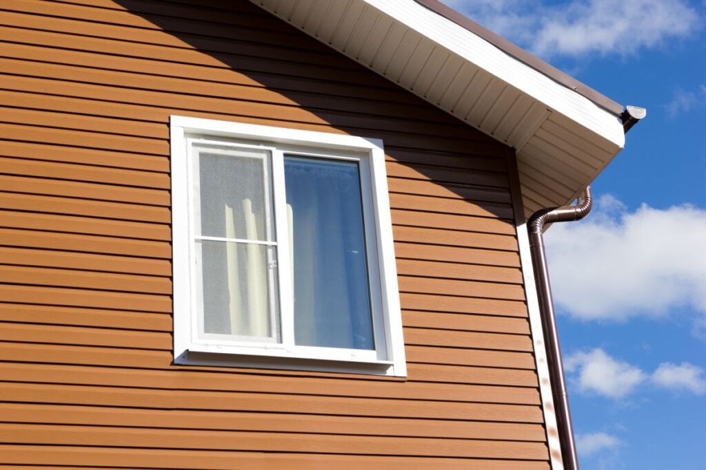window in wall of brown siding