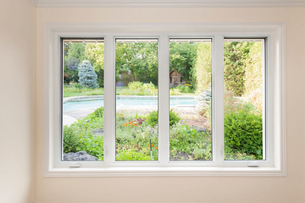 Casement window with view of summer backyard