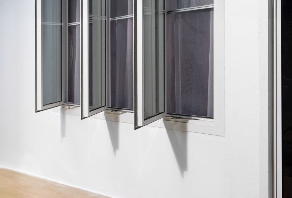 Three panel aluminium casement window stay on white wall